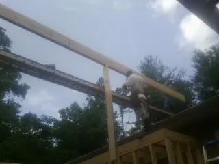 Carpenter setting a ridge beam over a new addition frame — Ice Dam Removal by Roofing Brothers in Pikeville