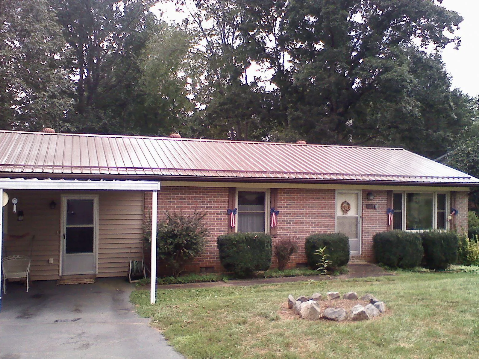 Bronze metal roof and carport on a brick ranch home — Roof Repair work by our crew in Pikeville